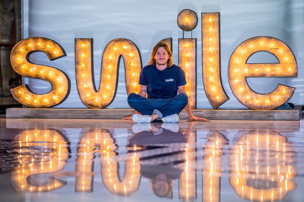 photo du fondateur de Swile avec le logo lumineux derrière lui